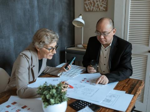 A man and woman reviewing paperwork at a desk