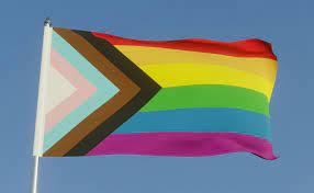 LGBTQ+ Flag against a blue sky 