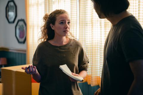 two people holding papers looking concerned with one another