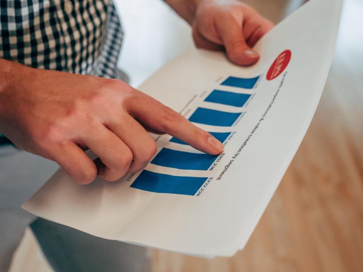 a person's hands looking at a chart on paper