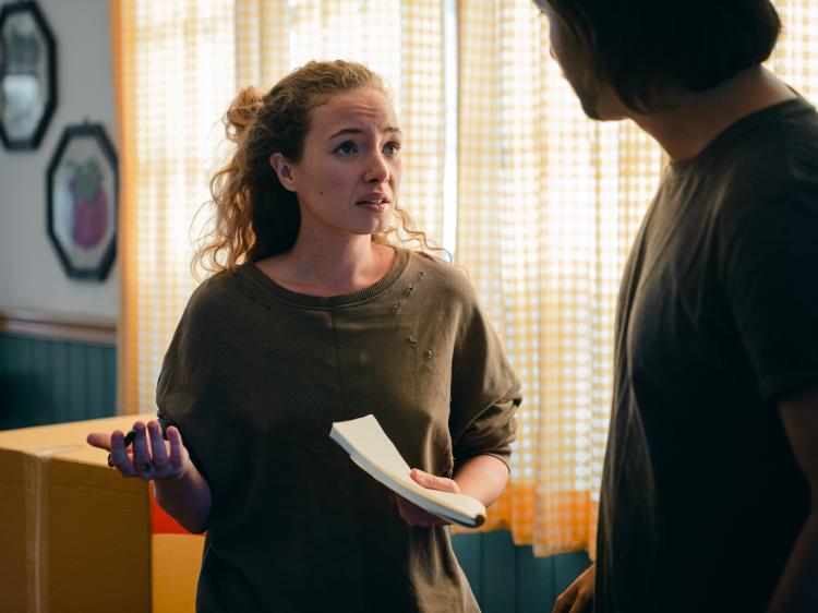 two people holding papers looking concerned with one another